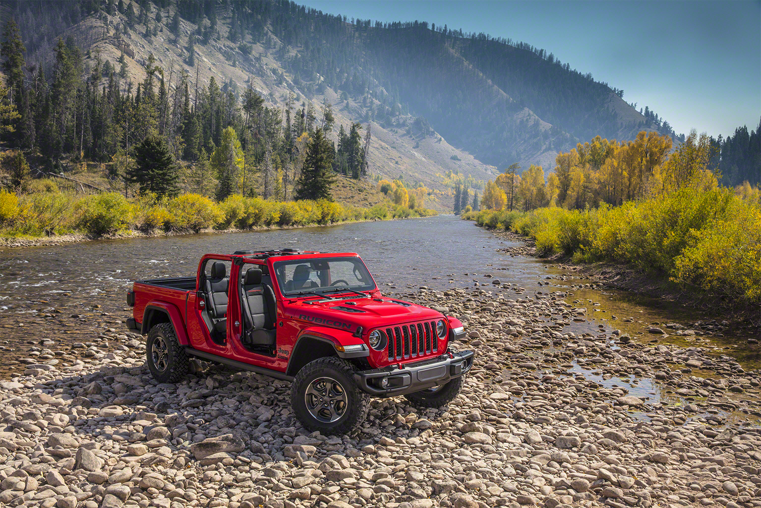 Red Jeep Gladiator parked in the mountains